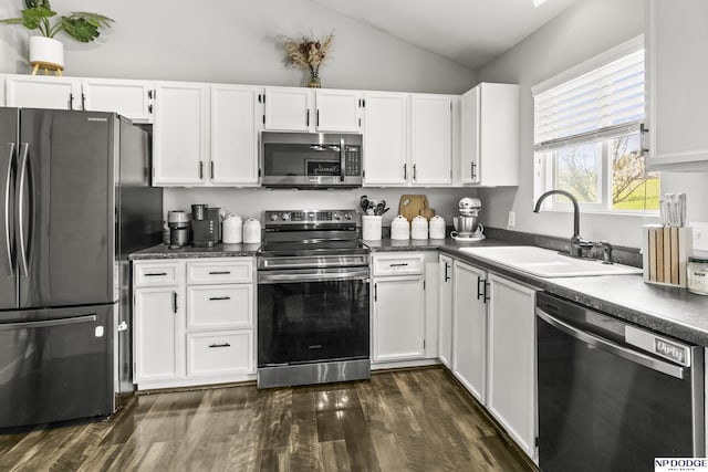 kitchen featuring a sink, dark wood finished floors, white cabinetry, lofted ceiling, and appliances with stainless steel finishes