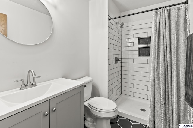 bathroom with a stall shower, vanity, tile patterned flooring, and toilet