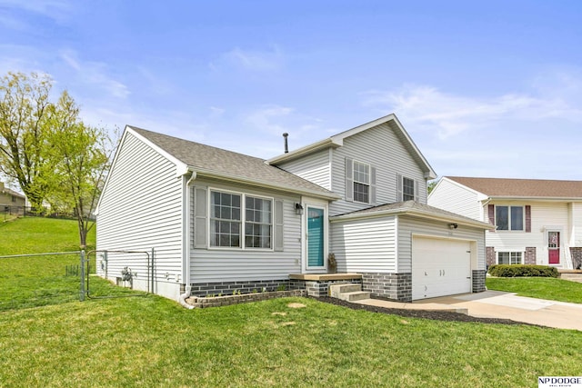 split level home featuring a front yard, concrete driveway, and fence