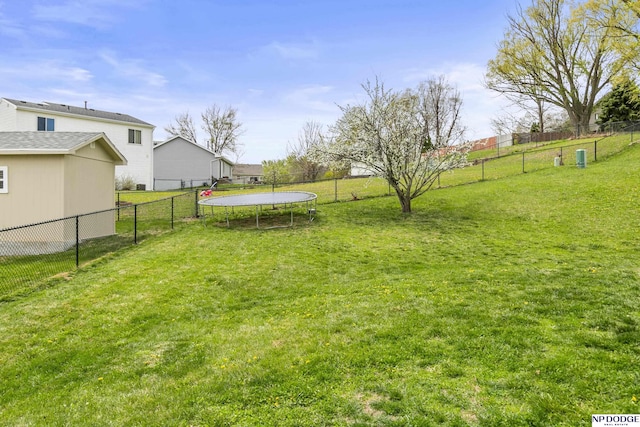 view of yard featuring fence and a trampoline