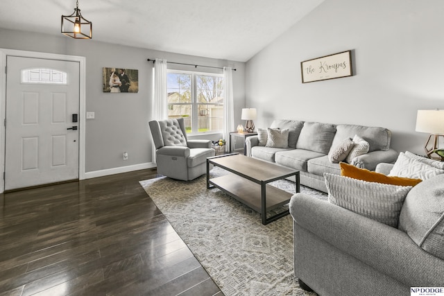 living area with lofted ceiling, baseboards, and dark wood finished floors