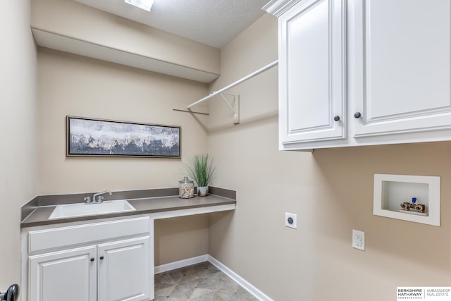 laundry area featuring hookup for an electric dryer, cabinet space, a sink, baseboards, and hookup for a washing machine