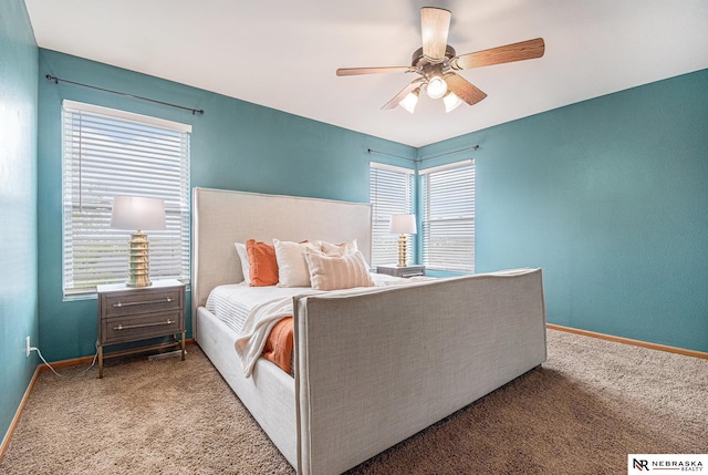 bedroom with a ceiling fan, baseboards, and carpet