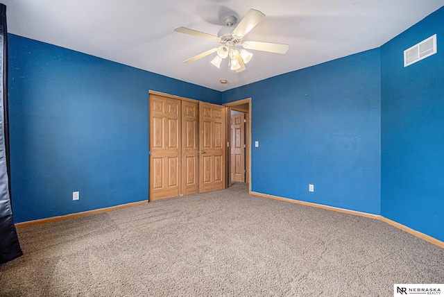 unfurnished bedroom featuring carpet floors, baseboards, visible vents, and a closet