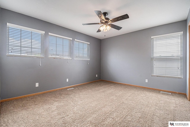 unfurnished room featuring baseboards, carpet, a ceiling fan, and visible vents