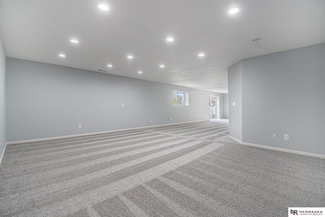 spare room featuring baseboards, light carpet, and recessed lighting