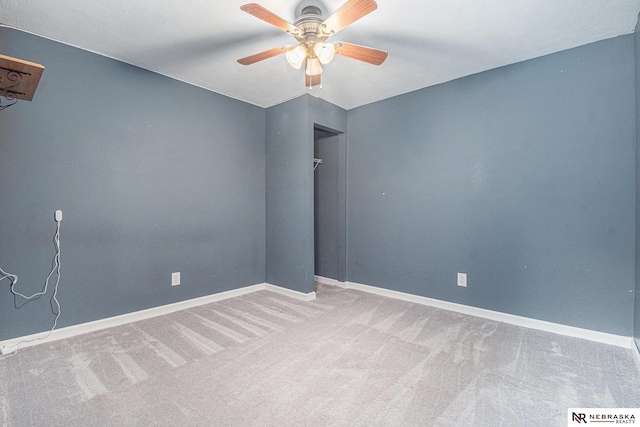 empty room featuring carpet floors, ceiling fan, and baseboards