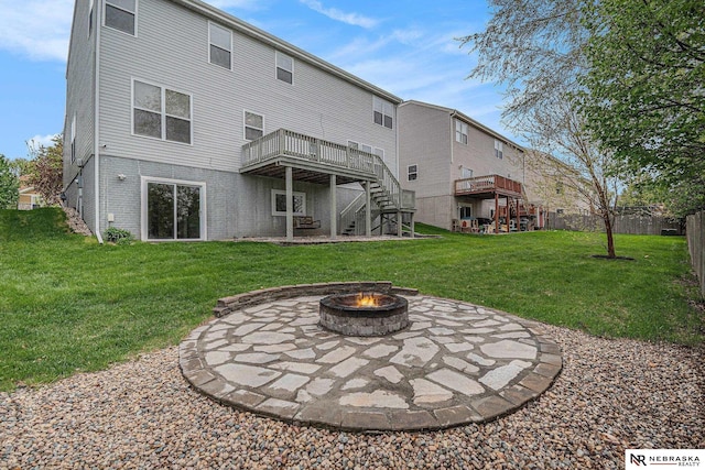 back of house featuring stairs, an outdoor fire pit, a wooden deck, a patio, and a yard