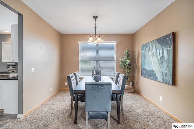 dining space with baseboards, a chandelier, and light carpet