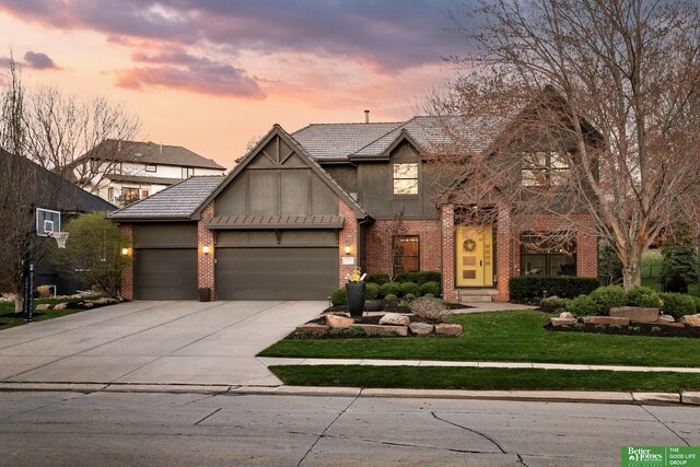 2307 S 184th Cir, Omaha, NE 68130 - view of front of home with a garage, concrete driveway, a front yard, brick siding, and stucco siding