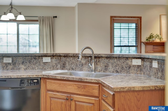kitchen with dishwashing machine, tasteful backsplash, light countertops, and a sink