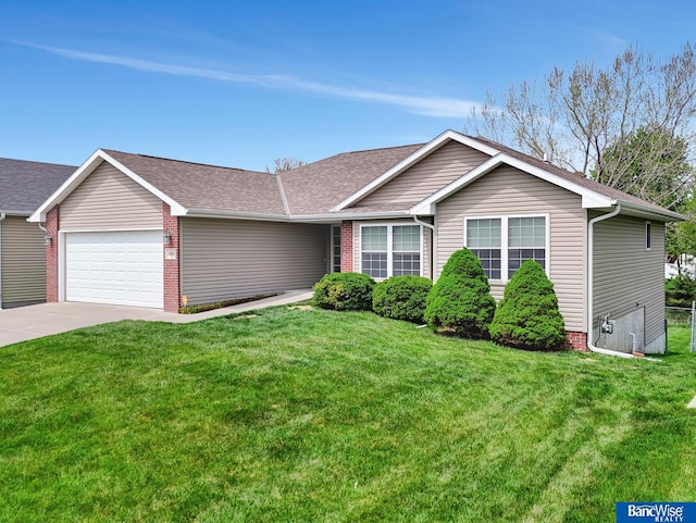 ranch-style home with roof with shingles, concrete driveway, a front yard, and a garage