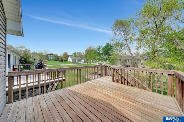 wooden terrace featuring a residential view and a yard
