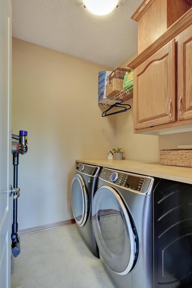 laundry room with separate washer and dryer, cabinet space, and baseboards