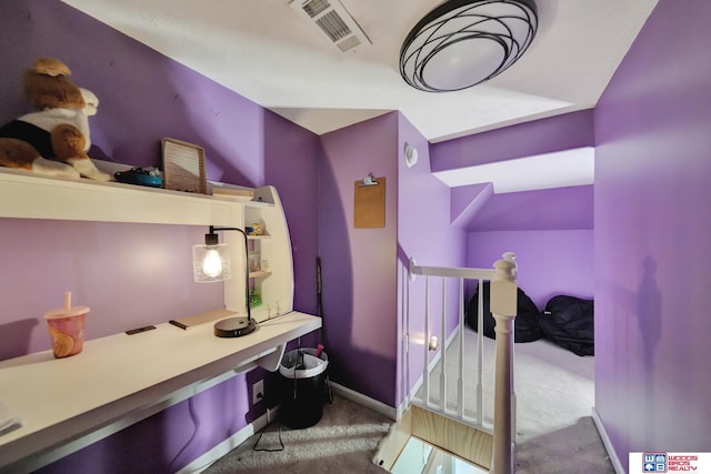 carpeted bedroom featuring a desk and baseboards