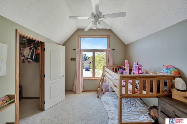 bedroom with a textured ceiling, carpet, vaulted ceiling, and ceiling fan