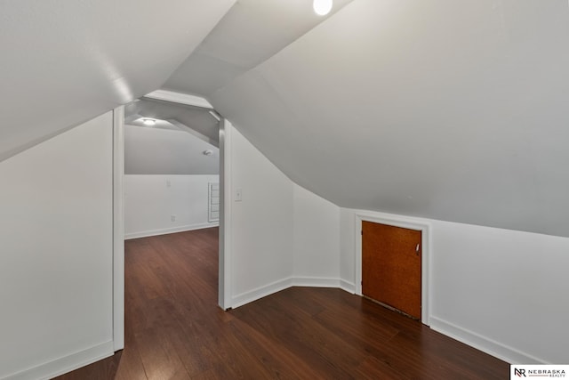 additional living space featuring baseboards, visible vents, wood finished floors, and lofted ceiling