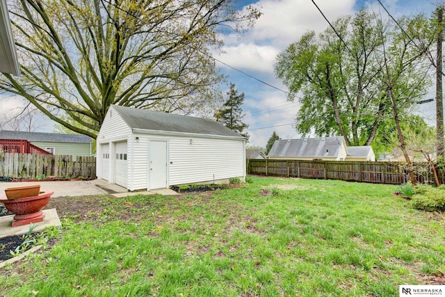 view of yard featuring an outdoor structure, a fenced backyard, and a garage