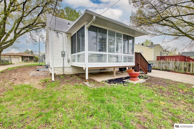 view of front of home with a sunroom and fence