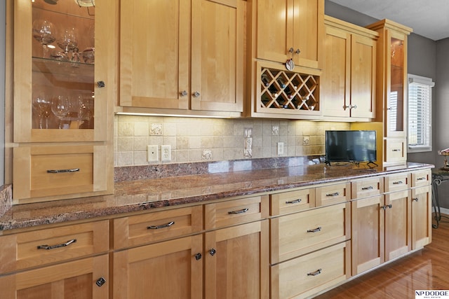 kitchen with decorative backsplash, light brown cabinets, dark stone counters, and dark wood-style flooring