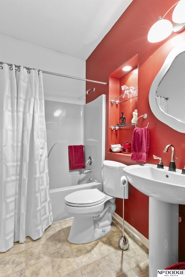 full bathroom featuring toilet, tile patterned floors, a sink, and shower / bath combo with shower curtain
