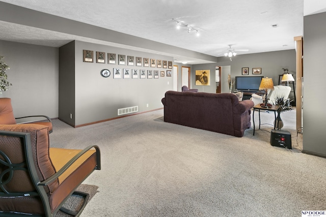 living room with baseboards, a ceiling fan, visible vents, and carpet floors
