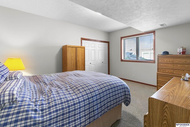 carpeted bedroom with baseboards, visible vents, and a textured ceiling