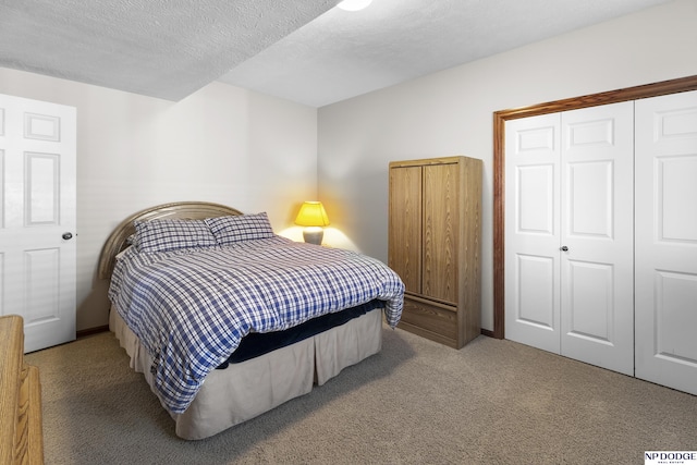carpeted bedroom with a textured ceiling and a closet