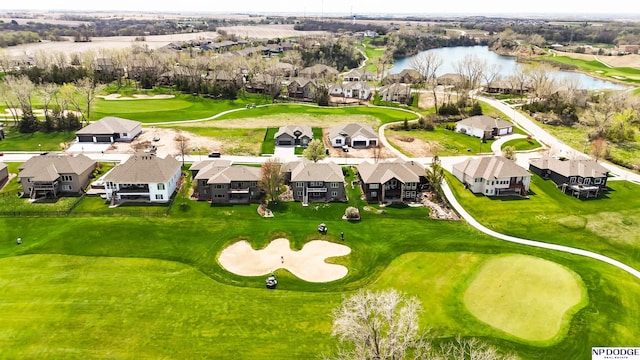 aerial view with golf course view, a residential view, and a water view