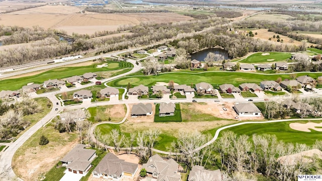 drone / aerial view featuring a residential view, golf course view, and a water view