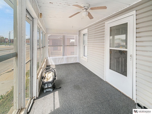 unfurnished sunroom featuring a ceiling fan