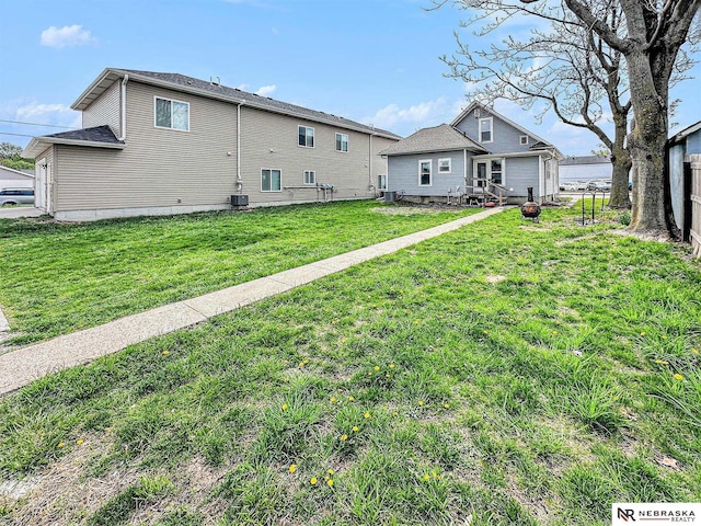 back of house featuring a lawn and fence