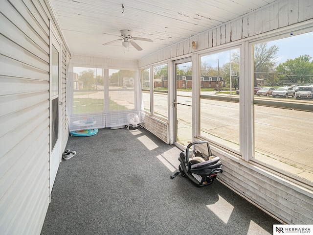 unfurnished sunroom featuring ceiling fan