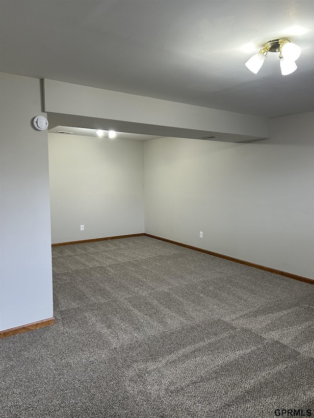 carpeted spare room featuring baseboards