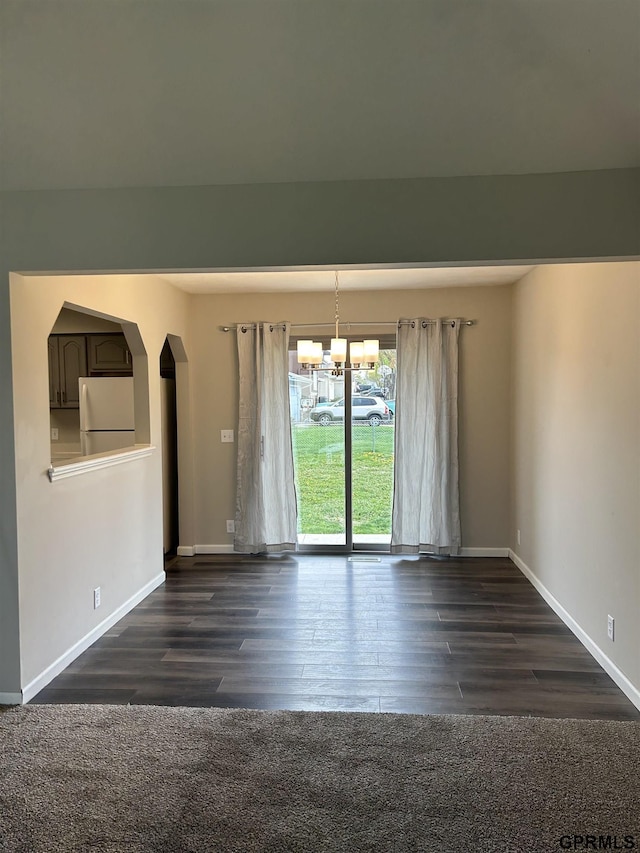 interior space featuring baseboards, an inviting chandelier, and dark wood-style flooring