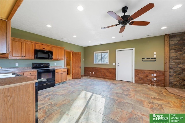 5850 Country Squire Plz, Omaha, NE 68152 - kitchen with black appliances, a sink, a wainscoted wall, stone tile flooring, and a ceiling fan