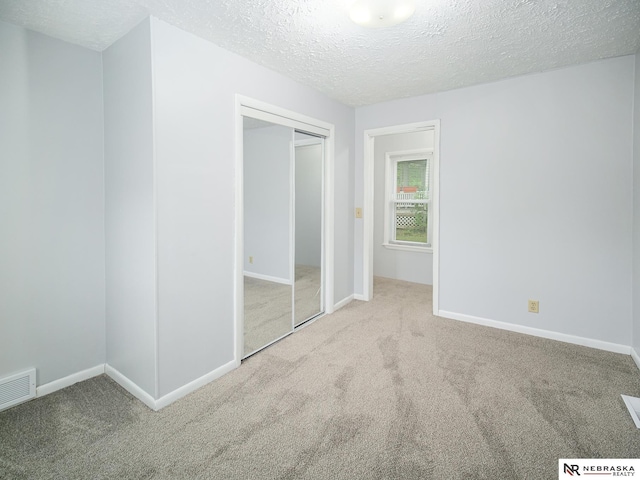 1029 Rose St, Lincoln, NE 68502 - unfurnished bedroom featuring carpet floors, a textured ceiling, baseboards, and a closet