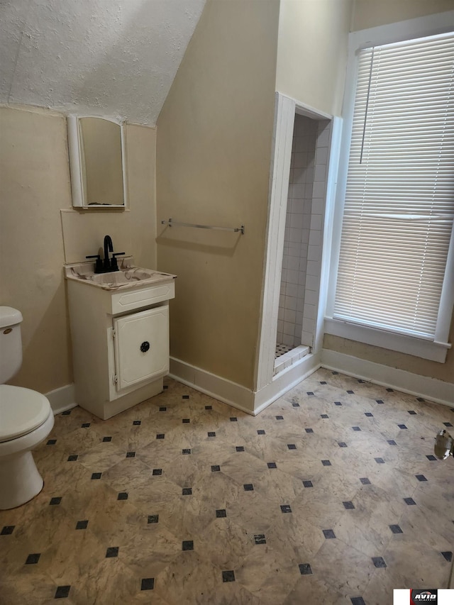 2103 A St, Lincoln, NE 68502 - bathroom with toilet, baseboards, a textured ceiling, a stall shower, and vaulted ceiling