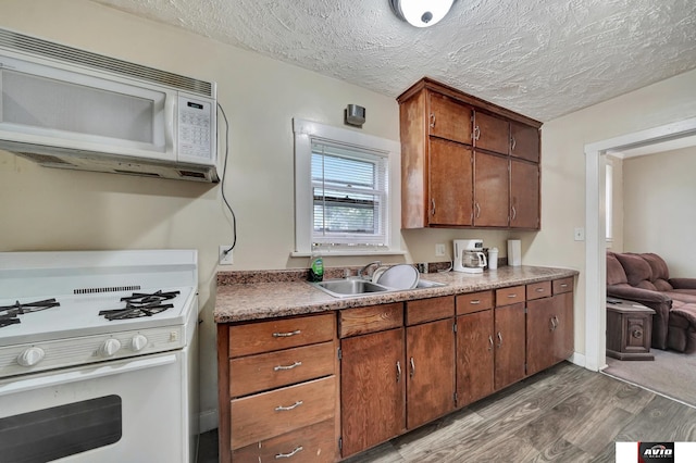 2103 A St, Lincoln, NE 68502 - kitchen with a sink, a textured ceiling, wood finished floors, and white appliances