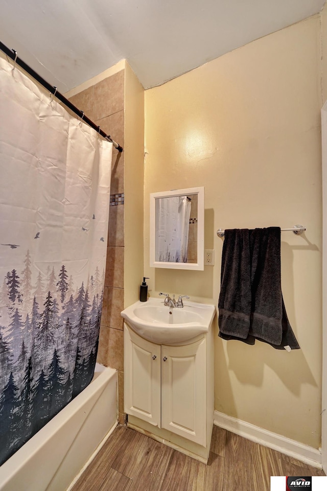 2103 A St, Lincoln, NE 68502 - bathroom featuring vanity, baseboards, shower / bath combo with shower curtain, and wood finished floors