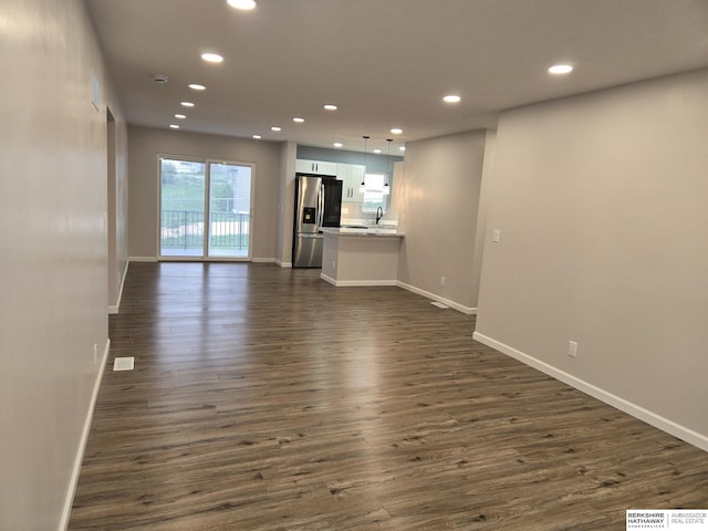 unfurnished living room featuring recessed lighting, dark wood finished floors, and baseboards