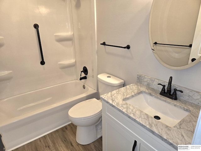 full bath featuring wood finished floors, toilet, shower / tub combination, and vanity