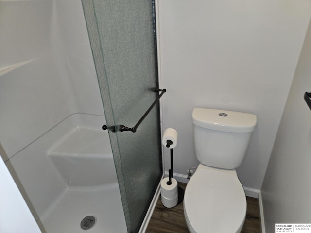 full bathroom with baseboards, wood finished floors, a shower stall, and toilet