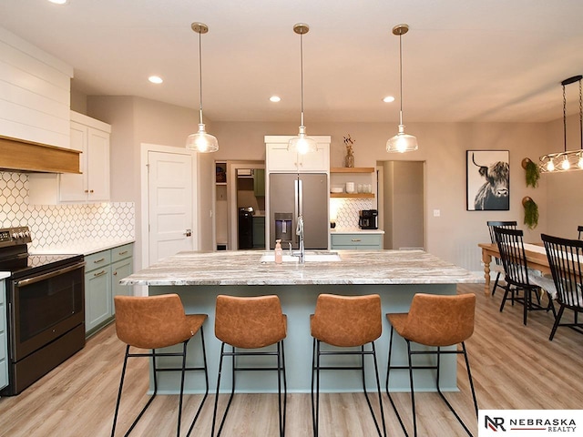 kitchen with decorative backsplash, stainless steel refrigerator with ice dispenser, electric range oven, open shelves, and a sink