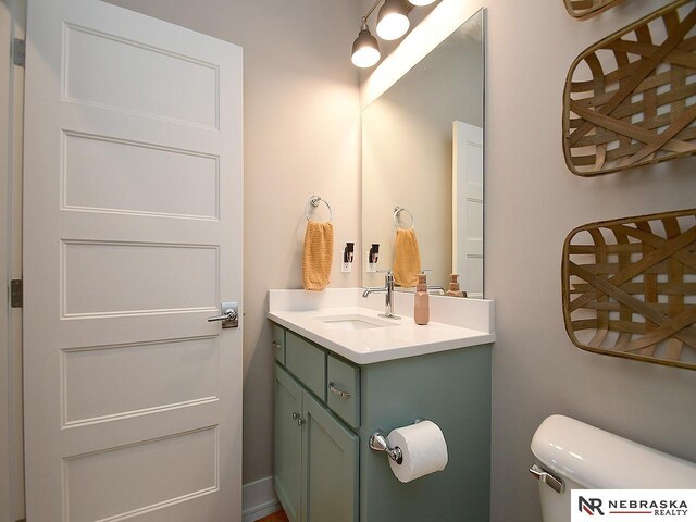 half bathroom featuring vanity and toilet