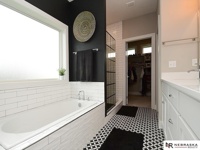 full bath with plenty of natural light, a stall shower, visible vents, and a spacious closet
