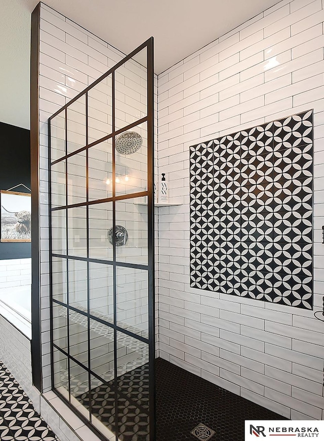 bathroom with a shower stall and a bath