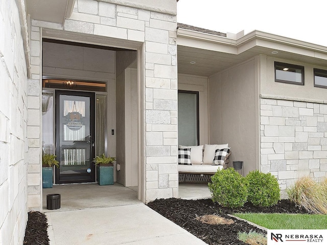 view of exterior entry with stone siding and concrete block siding