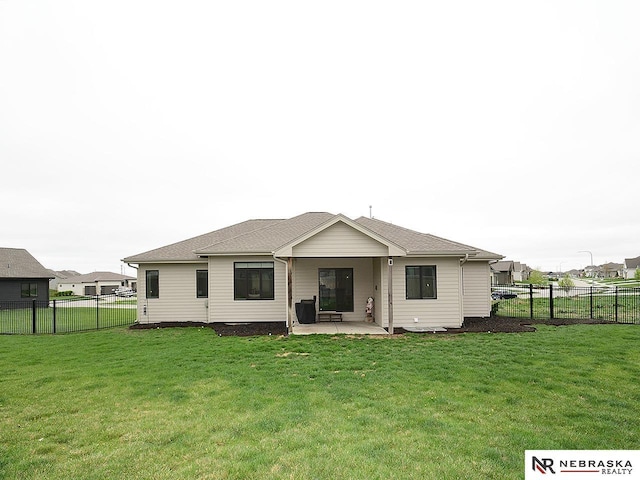 back of house featuring a patio, a fenced backyard, and a lawn