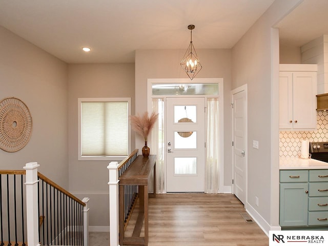 foyer featuring a chandelier, light wood-style flooring, recessed lighting, baseboards, and visible vents